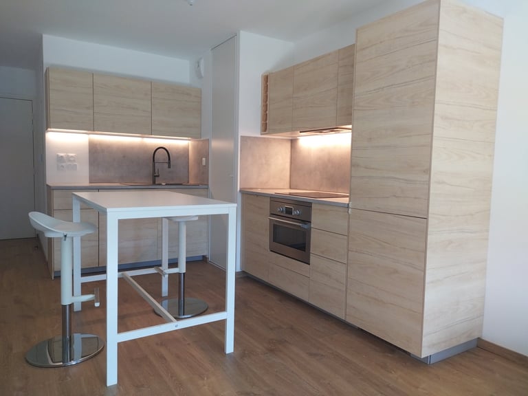 Cuisine conçue et montée appartement neuf à Tours façades aspect hêtre plans de travail ciment