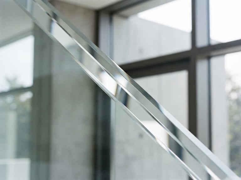 Crisp architectural close-up of a diamond-polished beveled glass edge, reflecting bright natural daylight, clean lines, high-contrast minimalist aesthetic, 35mm