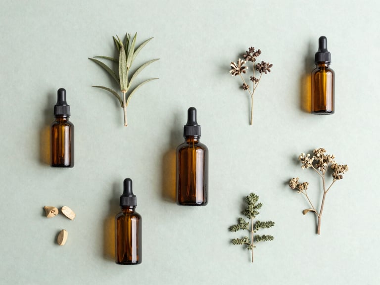 Minimalist flat-lay of raw botanical ingredients and clean amber glass bottles on a light sage green surface, soft natural overcast daylight