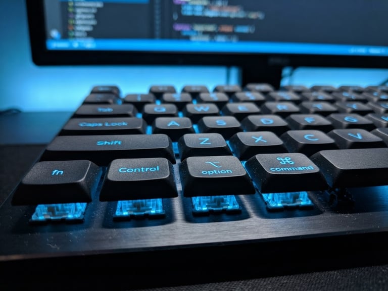 Macro close-up of a clean mechanical keyboard with sharp blue backlighting, focused on the command keys, cool blue screen-glow, 50mm lens