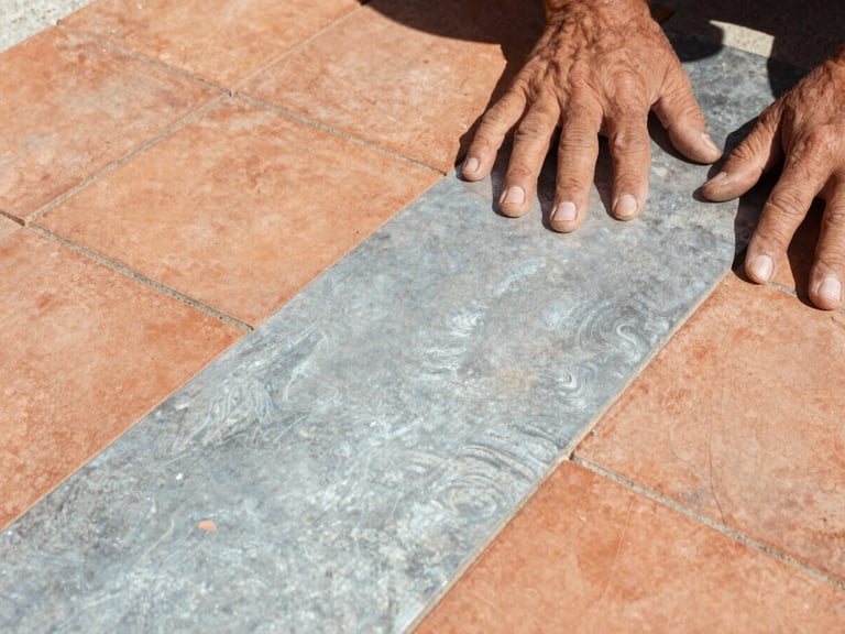 Macro texture shot of hands laying traditional terracotta tiles under harsh bright sunlight, rugged documentary photography, 35mm