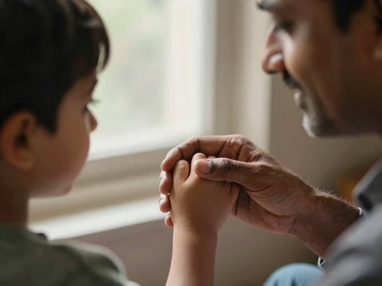 Close-up of a reassuring human interaction: an Indian father gently holding his child's hand, soft natural window light, shallow depth of field, warm tones.