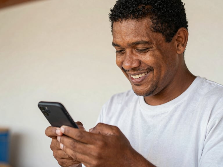 Medium close-up of a Brazilian worker using a smartphone, smiling with relief, with a clear digital interface on screen, in natural daylight with warm tones.