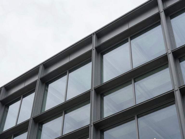 Architectural detail of a modern steel and glass commercial structure, low angle shot, overcast daylight, sharp focus