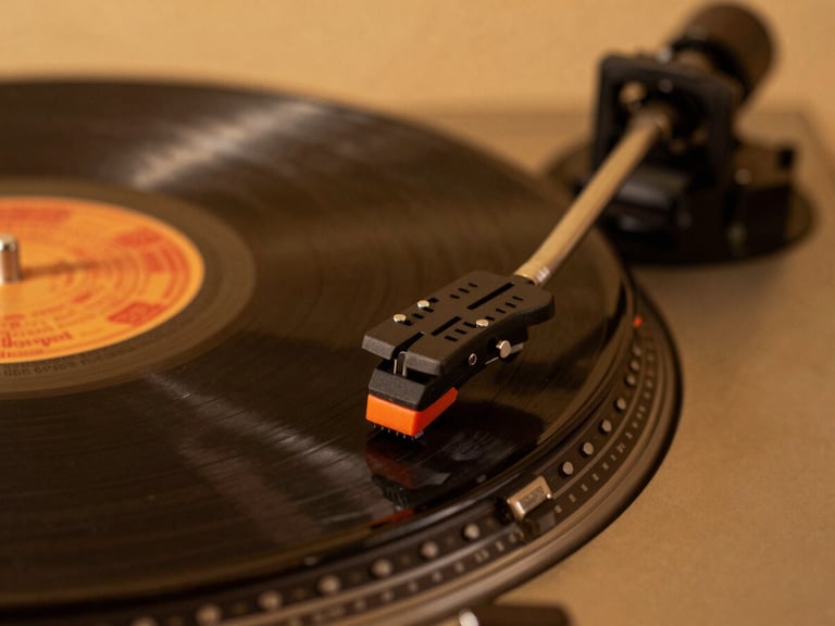 Macro shot of a vintage turntable needle resting on a vinyl record, warm amber studio lighting, rich dark tones, 35mm