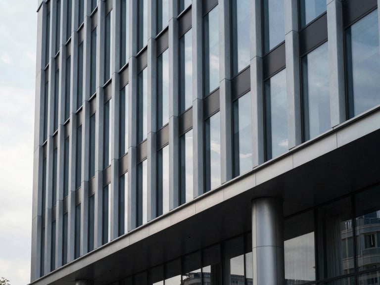 Minimalist architectural detail of a modern corporate building facade in Chișinău, sharp clean lines, steel and glass under cool overcast morning light.