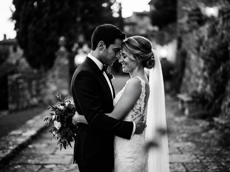 Dramatic emotional black-and-white wedding portrait, high-contrast cinematic lighting, shallow depth of field, 35mm anamorphic lens, elegant couple in quiet embrace