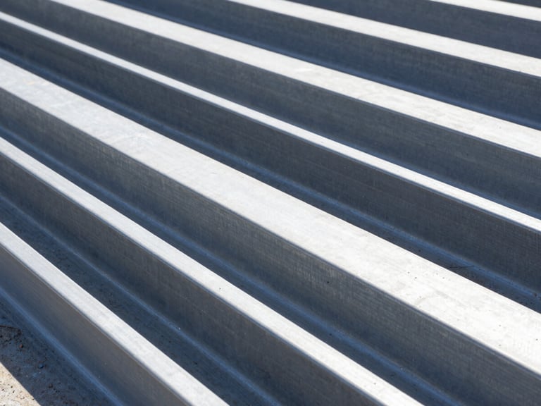 Uniones de acero estructural de alta precisión en una obra en construcción, con detalles de pernos y soldaduras, luz diurna brillante, sombras de alto contraste.