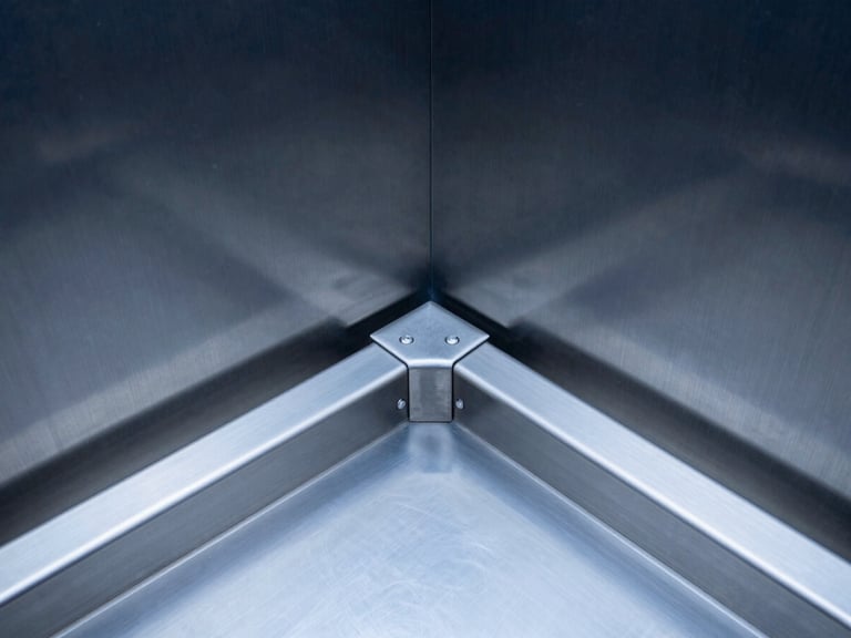 Macro technical shot of a brushed stainless steel elevator door mechanism, clean geometric alignment, sharp focus on mechanical tracks.