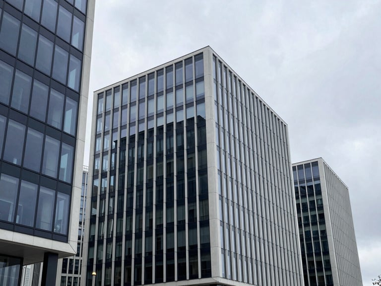 Wide-angle architectural view of modern glass business centers in Vilnius under a cool overcast sky, sharp geometric concrete lines, 35mm minimalist corporate photography