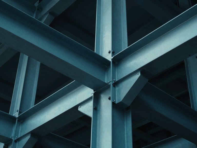 Extreme low-angle architectural photograph of a complex structural steel joint, cool cyan ambient light reflecting off sharp metallic edges, deep shadows, 35mm lens, ultra-sharp details