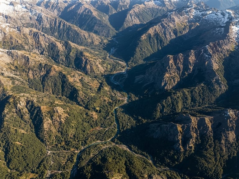 Extreme wide-angle aerial orthophoto of a rugged Chilean Andean valley at sunrise, sharp topographic contours, crisp morning sunlight, deep forest green and earth tones, 35mm lens