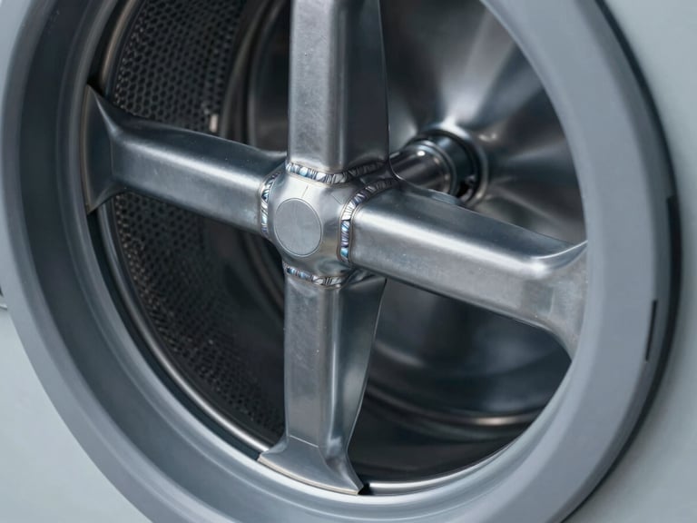 Close-up, high-fidelity technical render of the heavy steel frame of a commercial washing machine, emphasizing structural integrity and robust welds, cool studio lighting, slate gray tones, sharp focus.