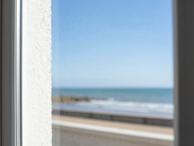 Close-up of a perfectly clean window pane, showing a sharp reflection of the Saint-Malo coast and bright sky, with water droplets evaporating, crisp whites and deep blues, sharp focus, 35mm