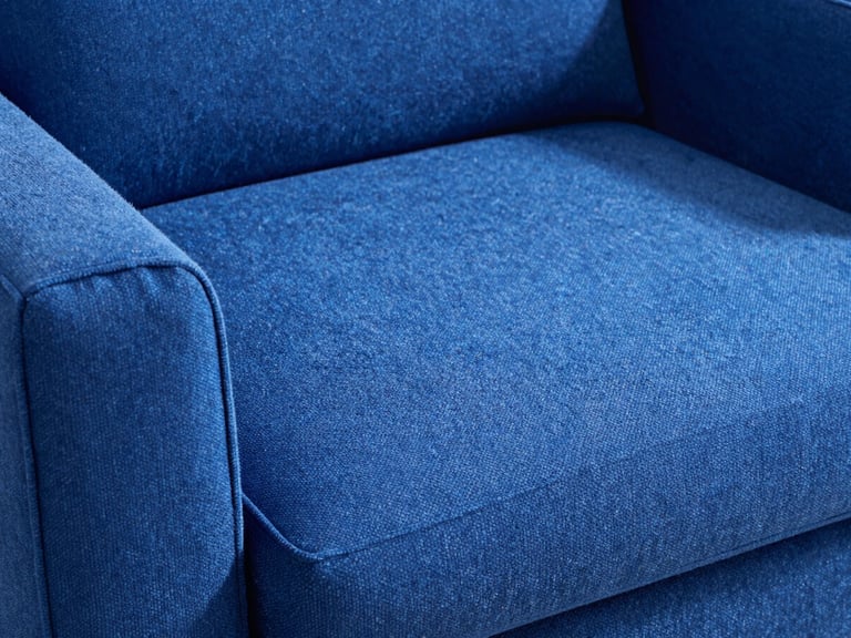 Close-up of a plush, deep blue sofa fabric, freshly cleaned, showing individual fibers and a subtle sheen under natural light, crisp whites and deep blues, sharp focus, 35mm