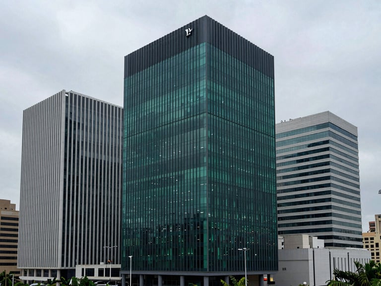 Wide panoramic shot of a modern Lagos financial district under cool overcast light, architectural lines of corporate bank headquarters, 35mm lens.