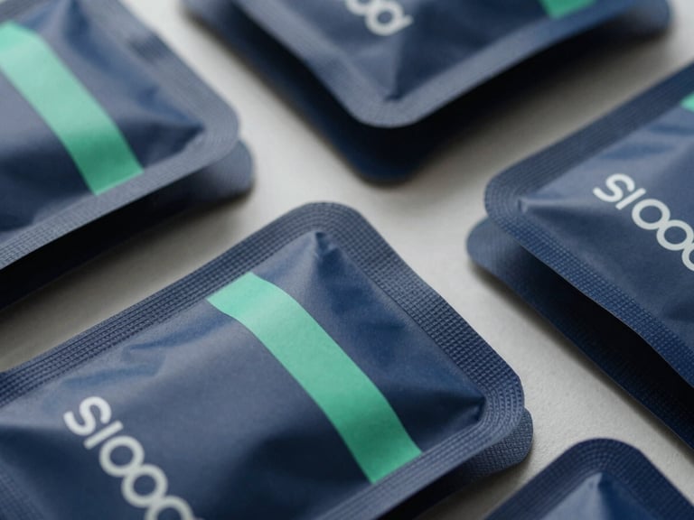 Macro overhead shot of high-end consumer product packaging ready for shipping, sharp shadows, cool natural daylight, deep navy tones