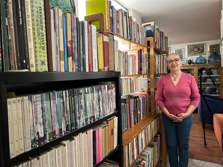 fotografia de Lilia Martínez y Torres con una parte de su colección de libros de Cocina Cinco Fuegos