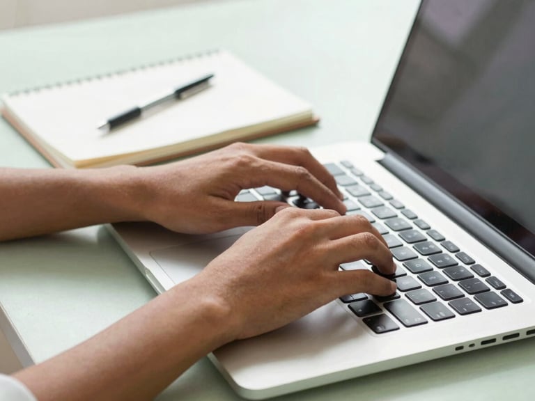 A Brazilian person's hands typing on a laptop keyboard, with a notebook open beside it, brainstorming ideas for extra income, bright natural daylight, soft shadows, warm tones, clean editorial photography, soft green and blue accents, realistic domestic setting, 35mm