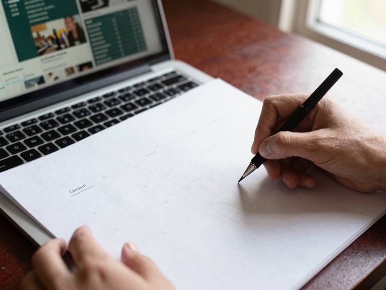 Overhead shot of hands sketching a content calendar on crisp parchment paper, a laptop with social media analytics open in the background, soft natural light, warm editorial photography.