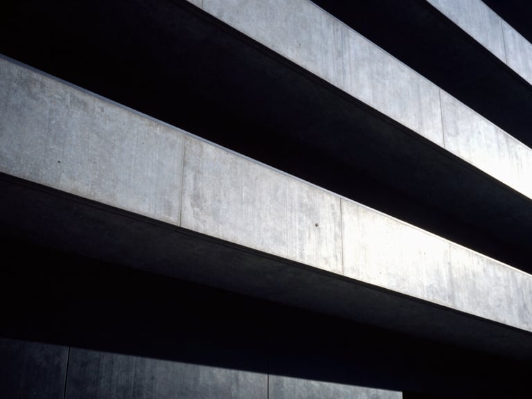 Imposing modern judicial architecture facade, sharp concrete angles, dramatic shadows, low-key cool-toned lighting, 35mm