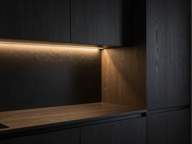 Moody architectural close-up of a minimalist kitchen at dusk, dark textured oak cabinets, soft golden light strip illuminating seamless joints, Hasselblad medium format