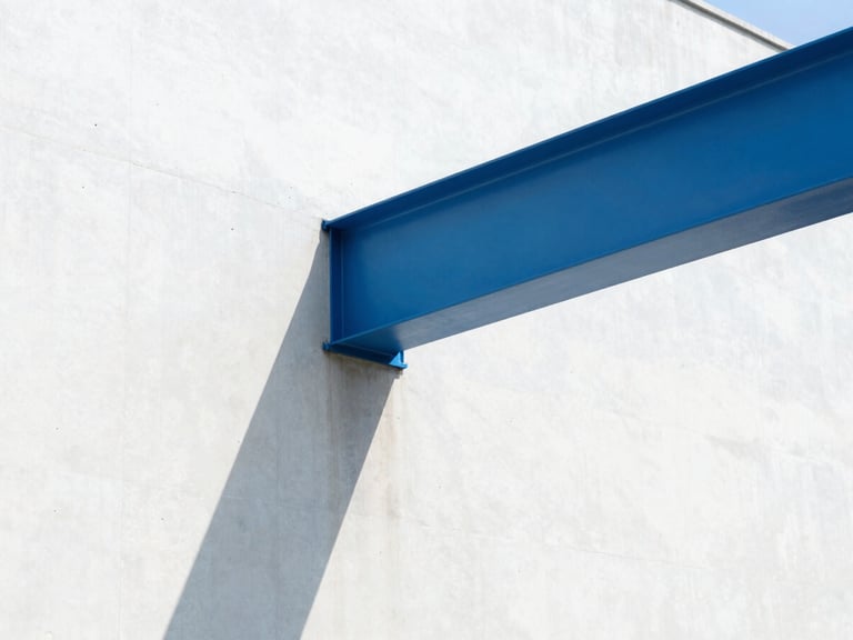 Bright architectural photography, sharp direct sunlight casting geometric shadows on a white concrete wall with an electric blue steel beam, 35mm
