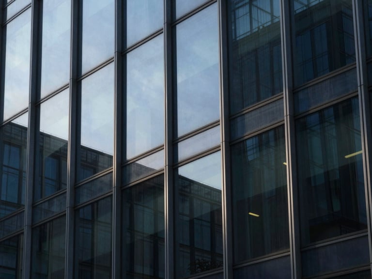 Macro details of modern glass office facade with sharp geometric shadows, cool morning light, deep navy and steel tones, 35mm