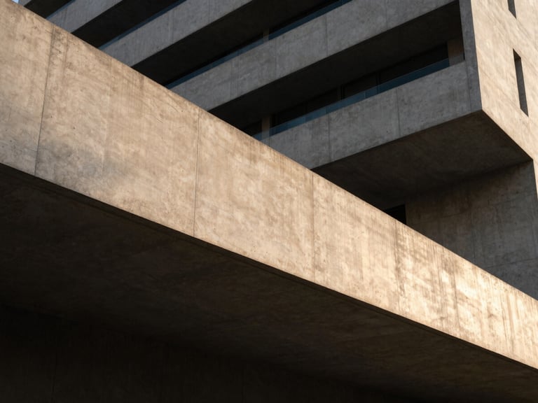 An abstract architectural wide angle of a modern concrete building facade with clean geometric lines, sharp shadows, and a sliver of champagne gold evening light, 35mm lens.