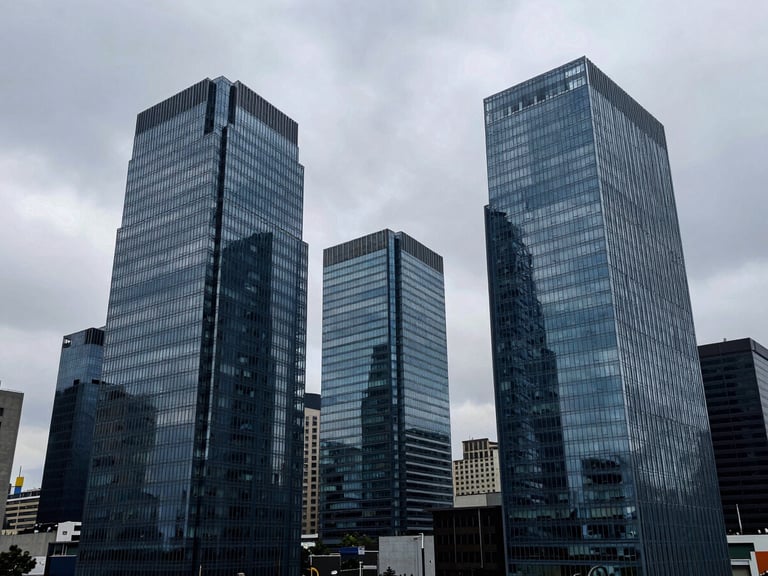 Wide panoramic shot of modern glass office towers in Bogotá financial district, cool overcast daylight, desaturated blue tones, 35mm