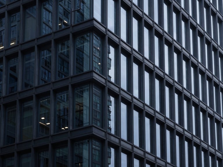 Abstract architectural details of a modern steel and glass building, cool clinical lighting, high contrast navy tones, 50mm.