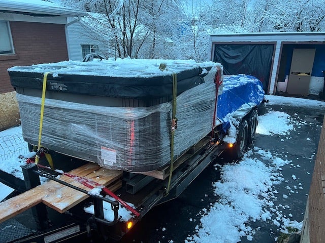 a hot tub on a trailer with lumber