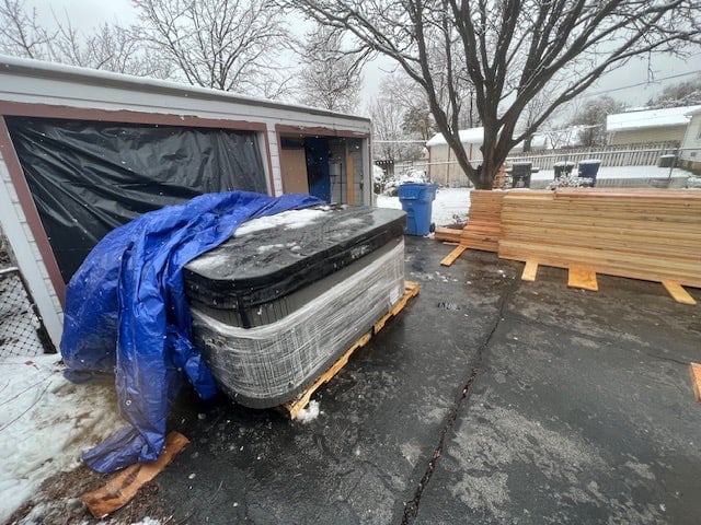 a hot tub in a driveway under a tarp