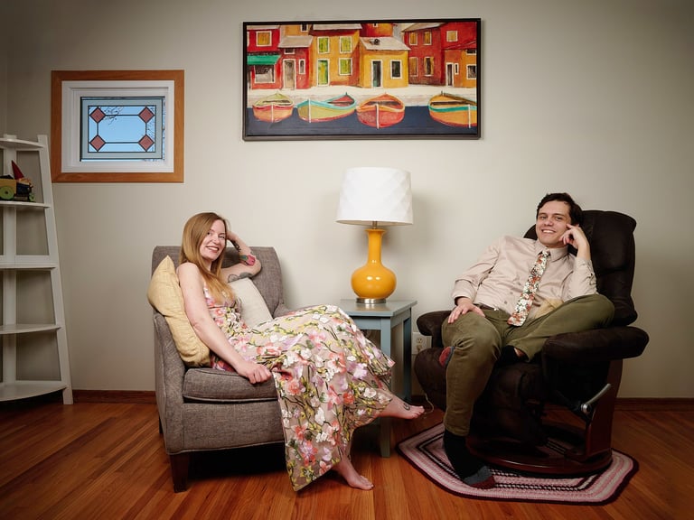 a man and woman sitting in a chair relaxing in the living room