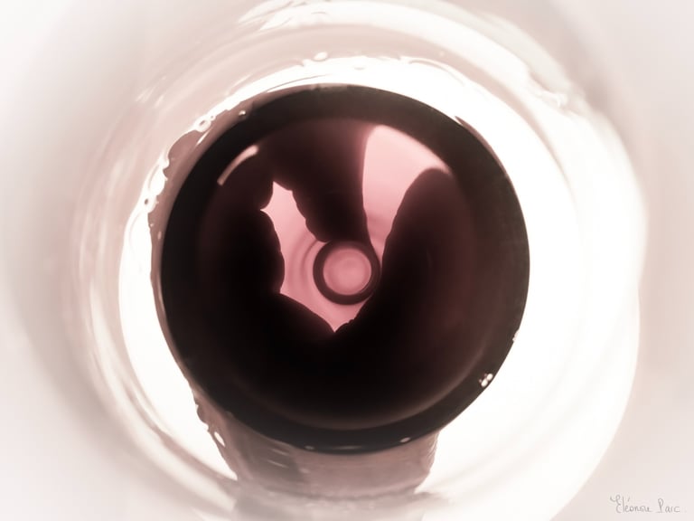 Surface de vin rouge traversée d’ondes lumineuses, effet d’astres en mouvement