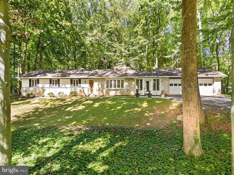 a house with a large yard and trees in the background