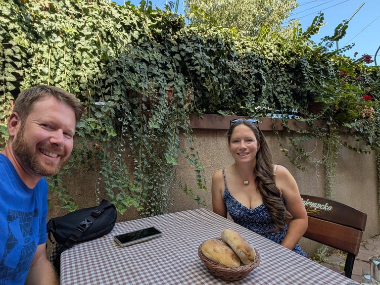 Don and Samantha eatting lunch at an outdoor table with ivy in Belgrade Serbia 