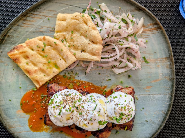 Giaurlou a greek dish made with mincedm eat topped with tomato sauce and yougurt in Thessaloniki, 