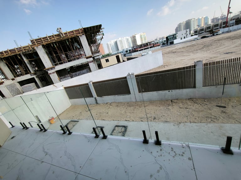 Frameless glass balcony railing with stainless steel spigot studs in Dubai.