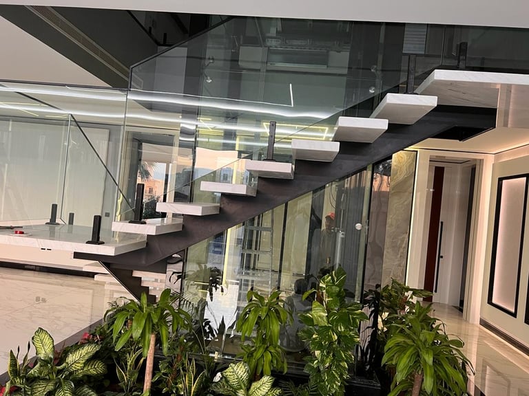 Modern structural steel staircase with frameless glass handrail and stainless steel fixings.