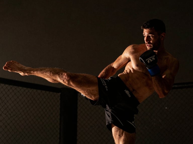 MMA fighter mid-kick, focused expression, dramatic low-key side lighting, deep charcoal and warm amber tones, 35mm lens.