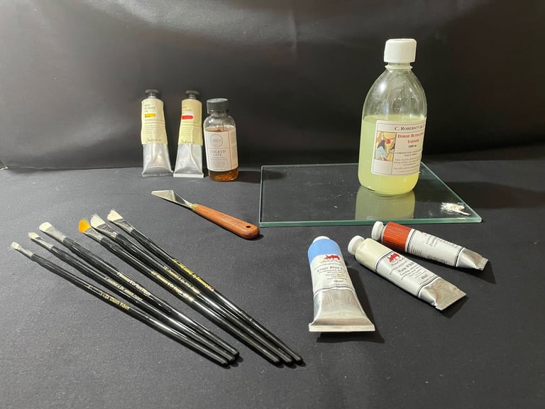 Professional oil painting supplies including brushes, paint tubes, and solvent on a black studio surface.