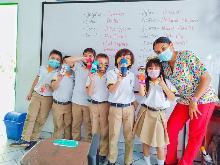a group of children and the teacher posing for a picture, after finishing a creative task