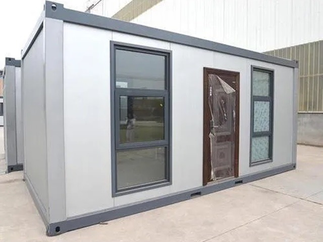 A prefabricated portable container office with modern glass windows and a secure brown door.