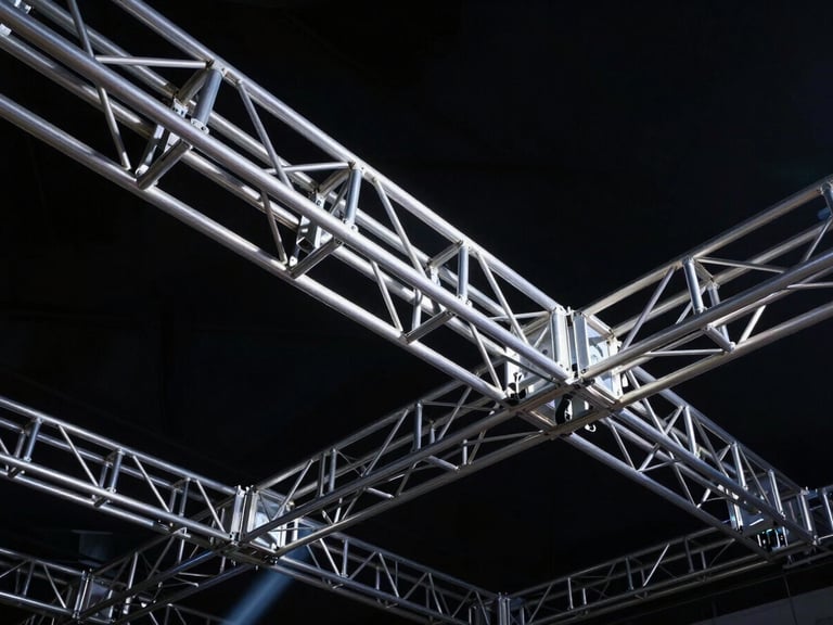 Low-angle heroic shot of heavy-duty aluminum trussing and rigging structures, sharp industrial lines against deep shadows, crisp technical details, 35mm.