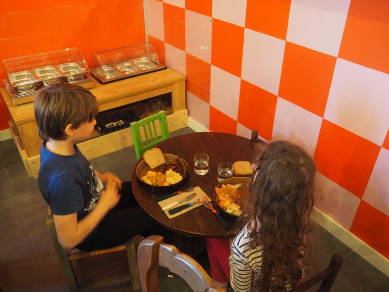 Enfants qui mangent en autonomie à table à côté du self-sevice enfant 