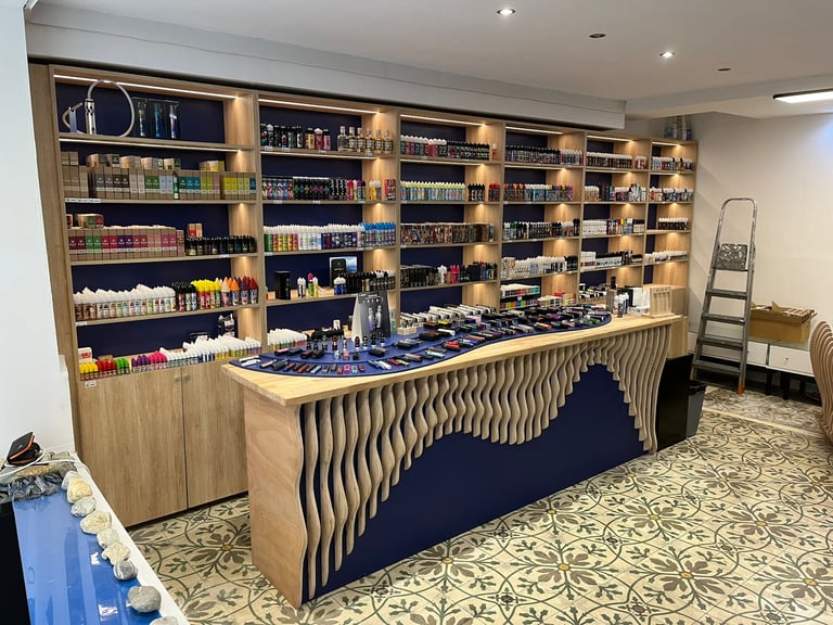 Modern vape shop interior with shelves of e-liquids and a display counter of vaping devices.
