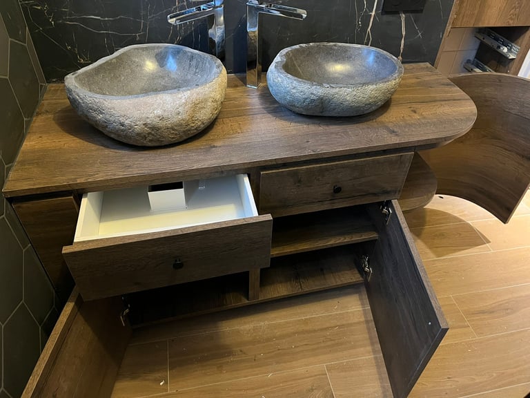 Rustic double stone vessel sinks on a dark wood vanity with modern chrome faucets.