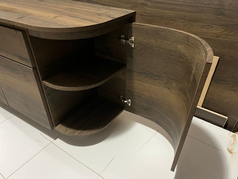 Dark wood grain sideboard cabinet with an open curved door revealing interior shelving.
