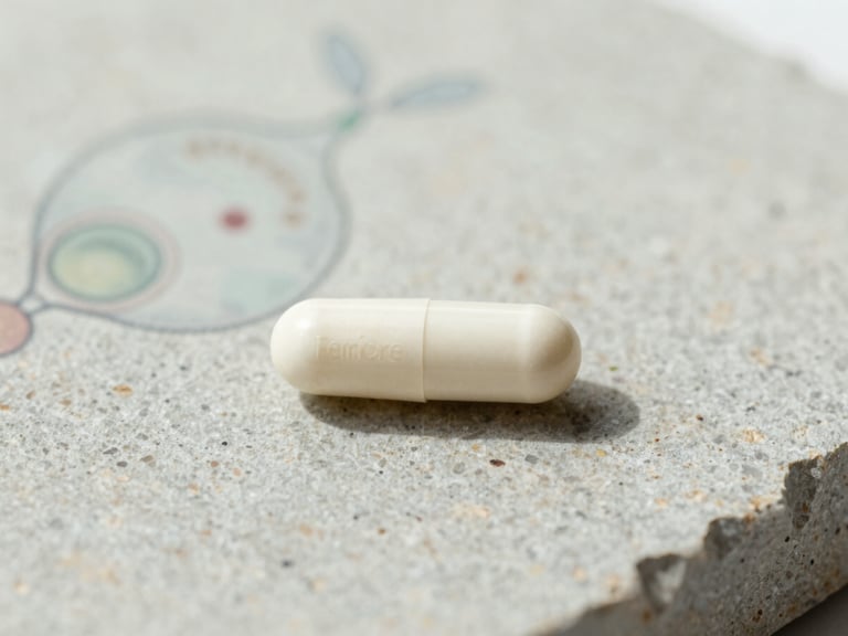 Clean white FemiCore capsule on textured stone, with a subtle scientific illustration of Lactobacillus Crispatus in the background, soft natural daylight.